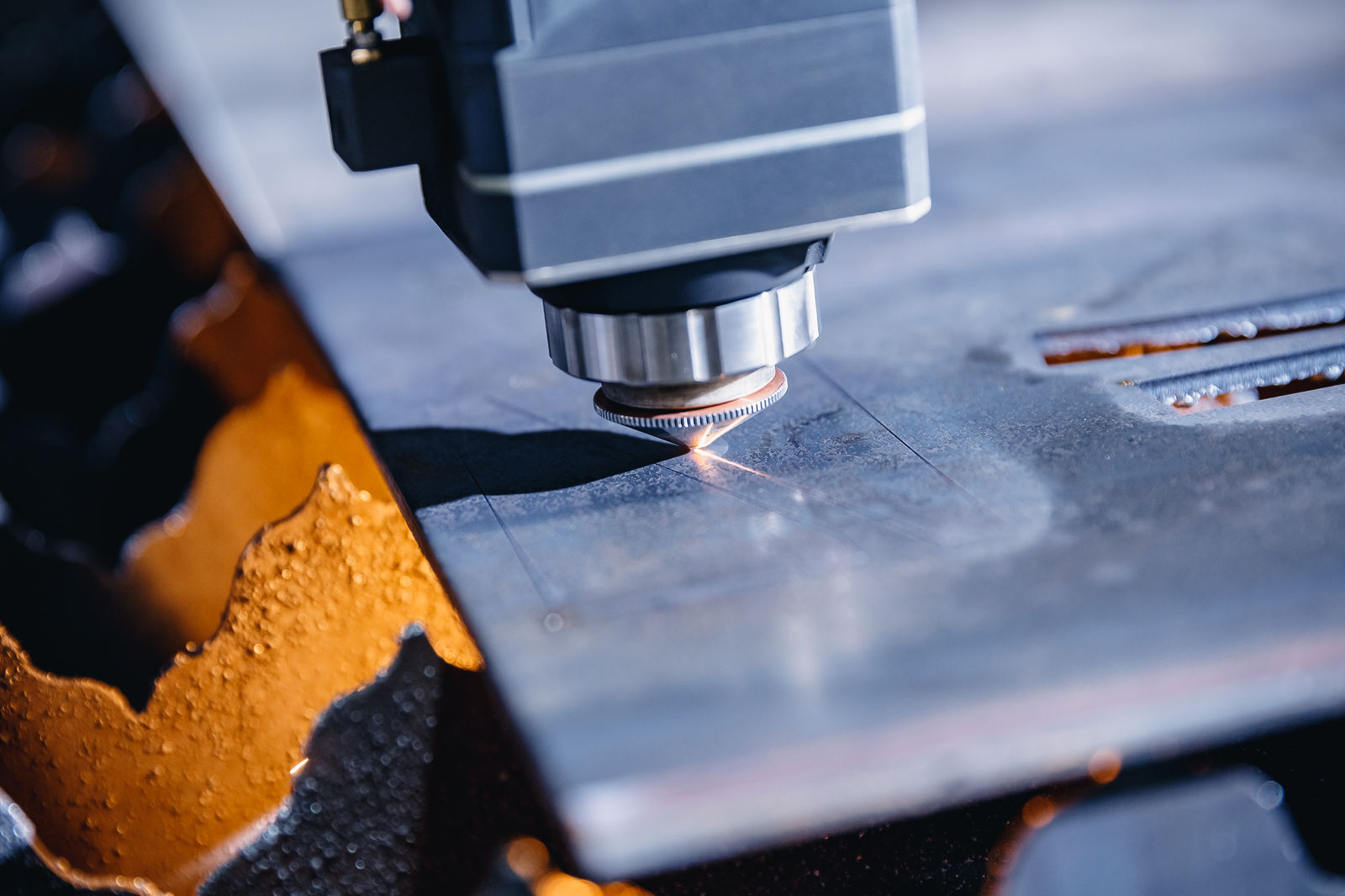 Laser cutting head close up on steel sheet